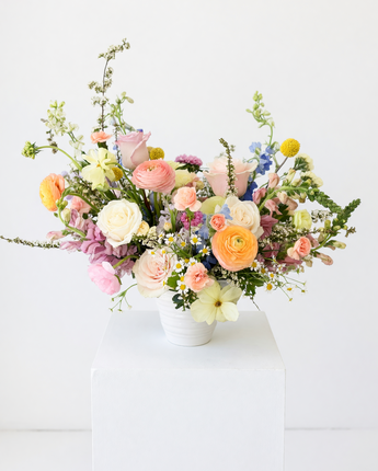 Colorful flower arrangement in a white vase on a white background