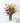 Bouquet of colorful flowers in a clear vase on a white surface with a white background