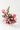 Bouquet of pink and purple flowers in a white vase on a white surface with a white background